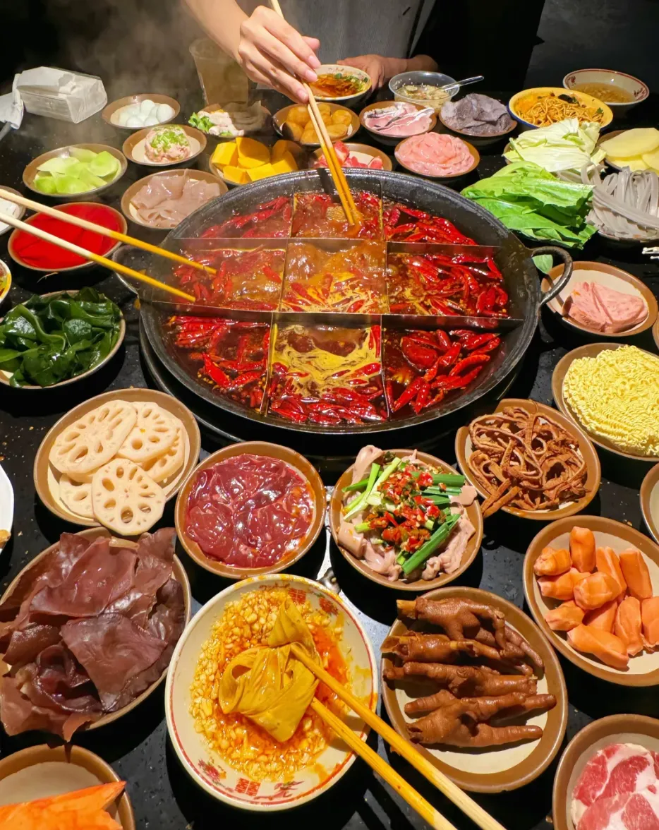 Chongqing nine-grid hotpot surrounded by small plates of ingredients