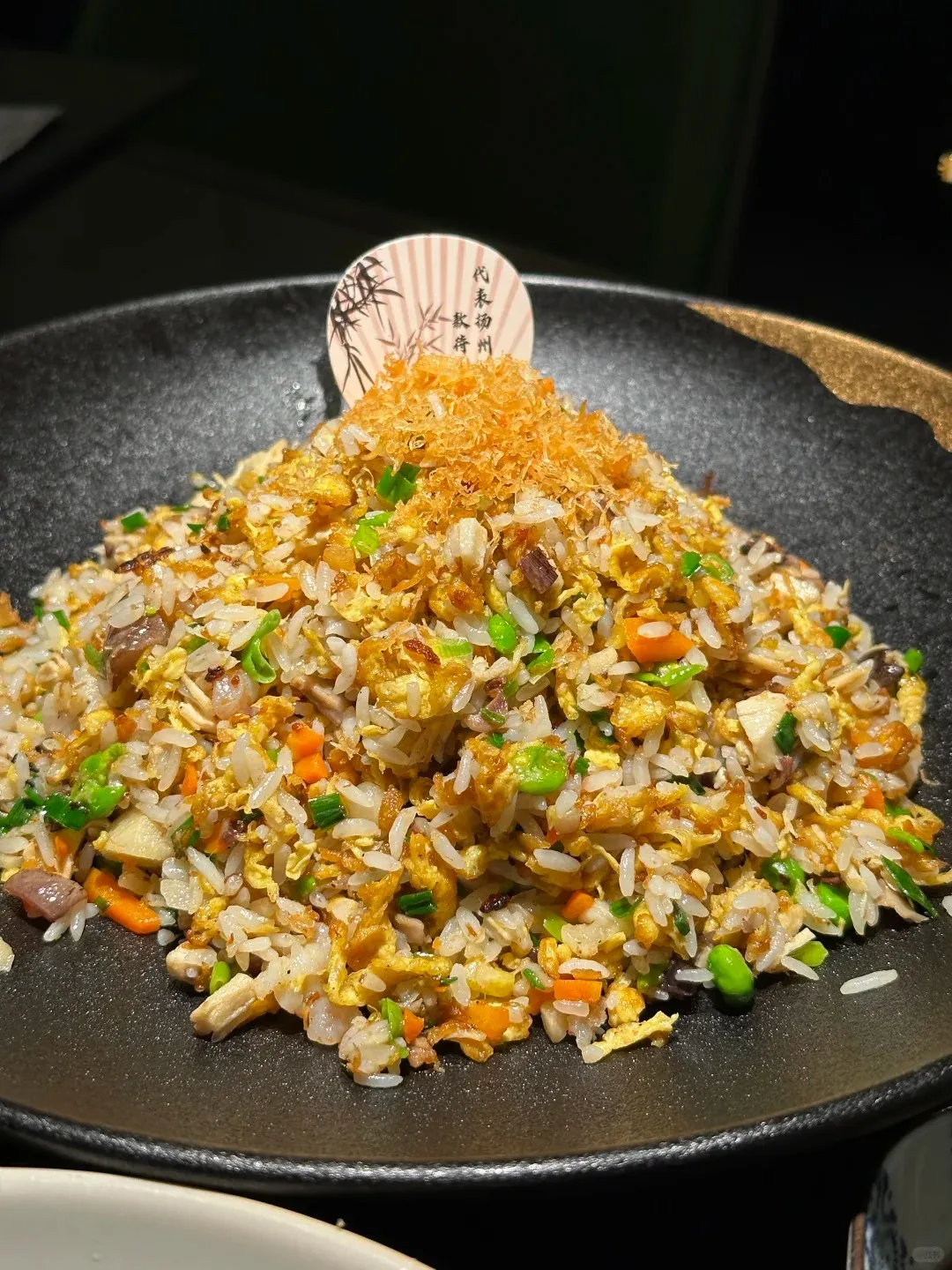 Yangzhou fried rice piled on a dark plate